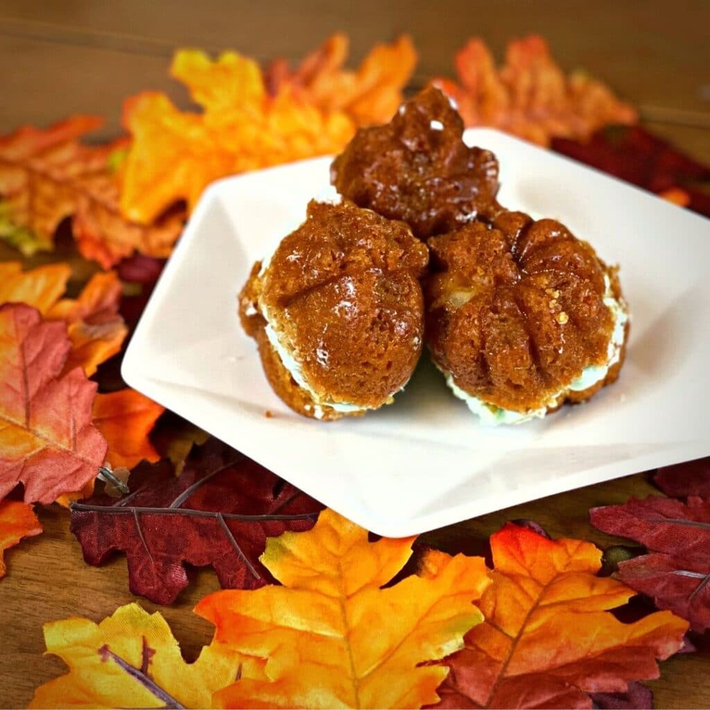 a Green Apple mini cake autumn recipe - A picture of autumn shaped sandwich cakes. An acorn shape, pumpkin shape and an autumn leaf shape. The cakes are caramel flavored with a light green green apple frosting in between.