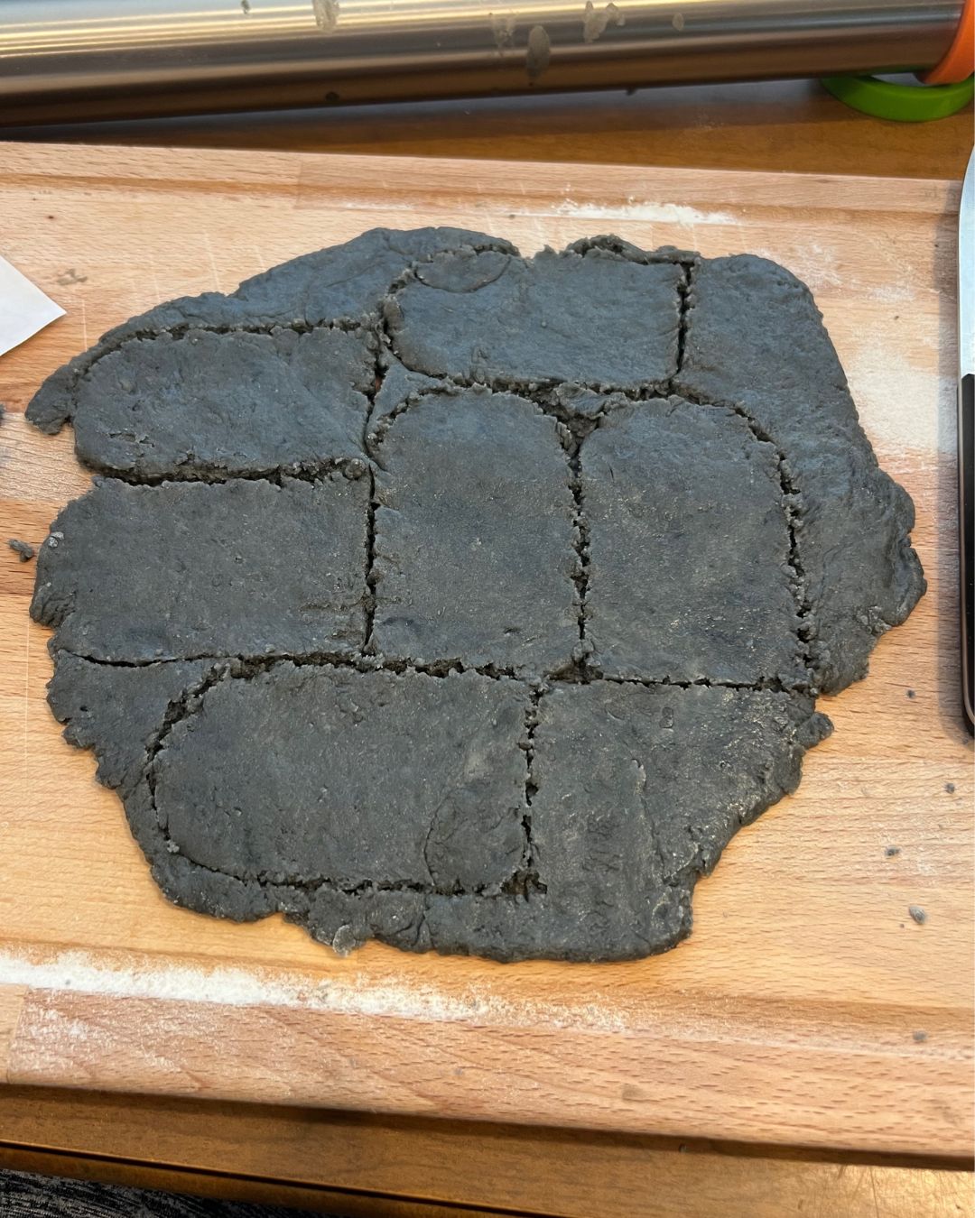 Oreo Dirt Cup Recipe -a grey slab of dough with tombstone shapes cut out.