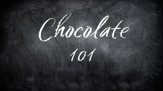 A black chalkboard looking background with the works "chocolate 101" written on it. In a white chocolate looking font.